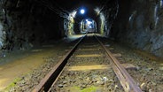 Die Schienen der Lore führen tief in den dunklen Bergwerksstollen © NDR Foto: Matthias Freund