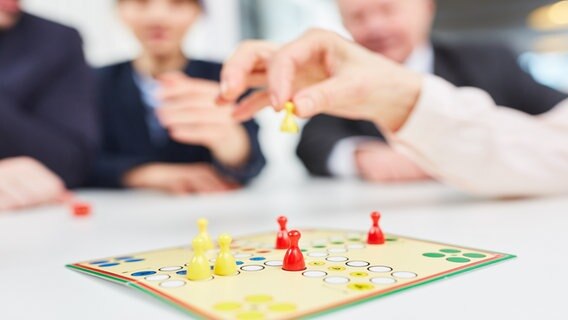 Mehrere Personen spielen gemeinsam ein Brettspiel. © Picture Alliance Foto: Robert Kneschke