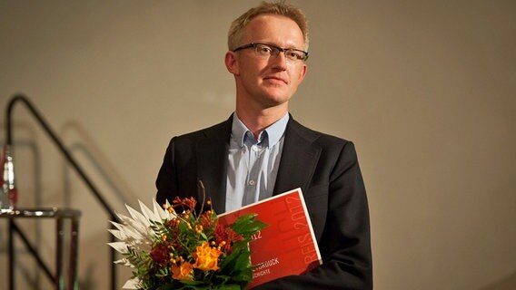David Van Reybrouck mit Blumenstrauß © NDR Foto: Mathias Todtenhaupt