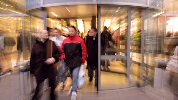 Menschen gehen durch eine Drehtür ©  imago/momentphoto/Killig 