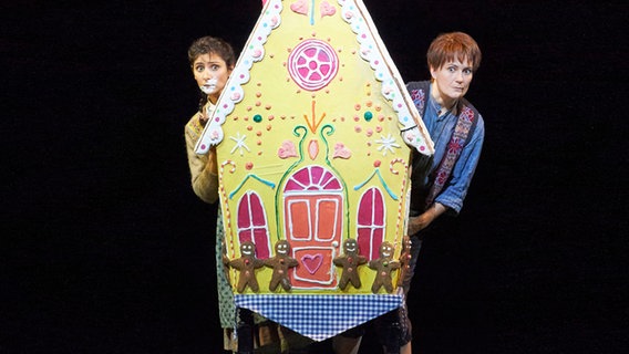 Hänsel und Gretel tragen ein Papp-Knusperhaus. © Wiener Staatsoper Foto: Michael Pöhn