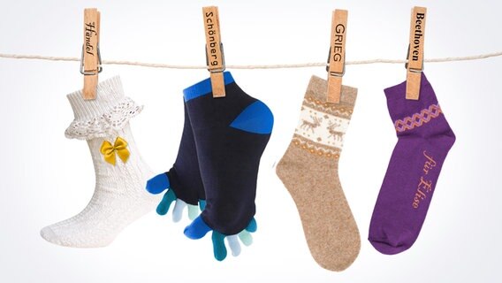 Vier Paar Socken hängen an einer Leine - mit unterschiedlichen Motiven. © Colourbox Foto: Christian Spielmann