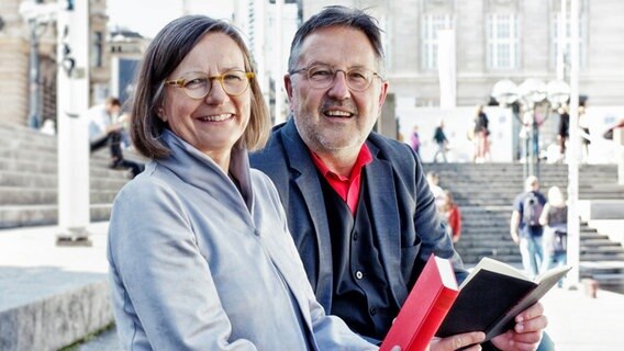 Annemarie Stoltenberg und Rainer Moritz sitzen auf den Stufen zur Alster © NDR/ Foto: Christian Spielmann