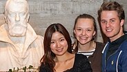 Die Sieger beim Internationalen Violinwettbewerb 2012 in Hannover stehen neben einer Büste des Violinisten Joseph Joachim : (v.l.nr.) Dami Kim (Südkorea), Alexandra Conova-Dumortier (Moldawien) und Tobias Feldmann (Deutschland). © Internationaler Joseph Joachim Violinwettbewerb 