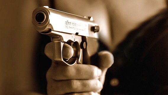 Nahaufnahme einer Schusswaffe in der Hand einer Frau - Sepiaton © panthermedia Foto: Franz Roth