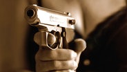 Nahaufnahme einer Schusswaffe in der Hand einer Frau - Sepiaton © panthermedia Foto: Franz Roth
