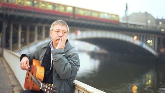 Der Liedermacher Wolf Biermann sitzt mit seiner Gitarre am Spreeufer © dpa Foto: Max Lautenschläger