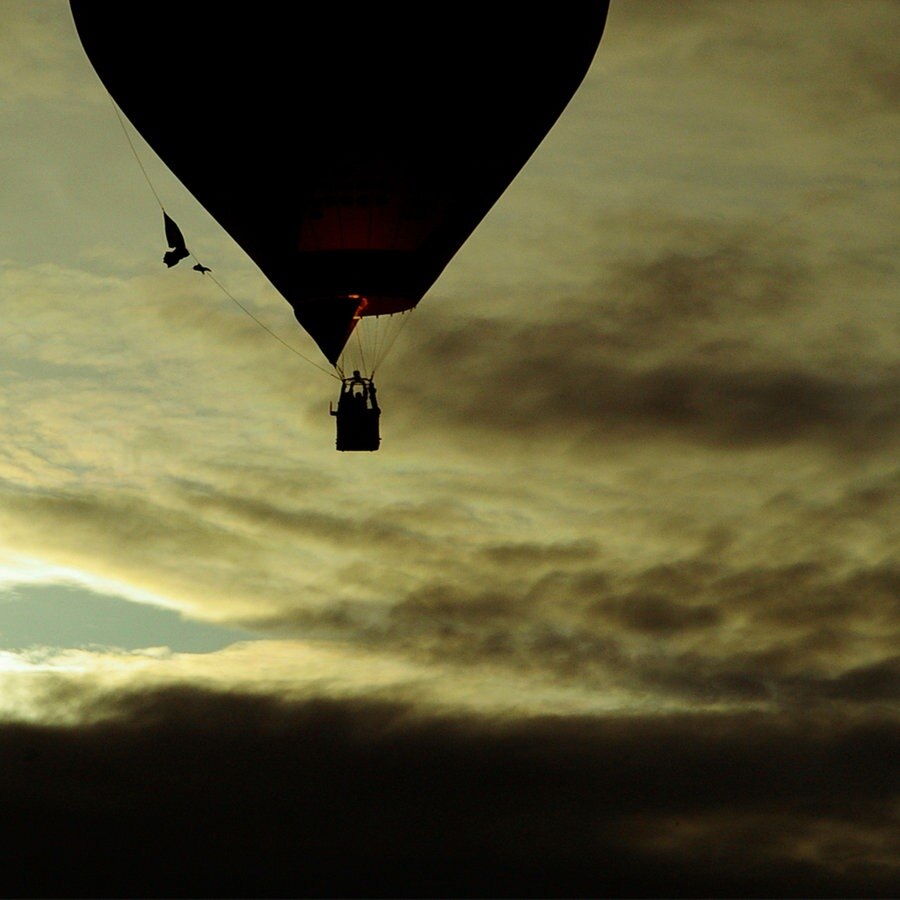 Ein Heißluftballon vor einem dramatisch aussehenden Himmel. © Yvonnes_photos / photocase.de Foto: Yvonnes_photos