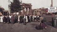 Westberliner warten an der Sektorengrenze auf ihre flüchtenden Angehörigen, Berlin 1953. (digital koloriert) © picture alliance / akg-images 
