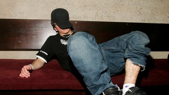 Jugendlicher schläft auf einer Bank. © picture alliance / PYMCA/Photoshot | Naki Foto: Naki