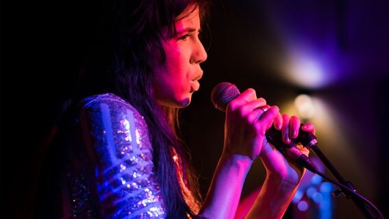 Eine Frau mit Mikrofon singend auf einer Bühne. © NDR Foto: Alex Potemkin 
