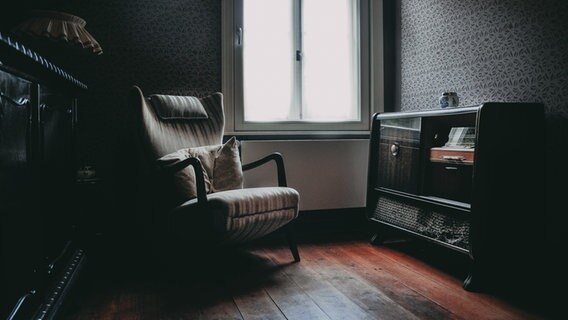 Ein dunkles Zimmer mit hellem Fenster, Sessel und Stereoschrank. © photocase Foto: Mathias Elle