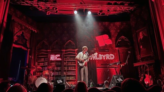 Maximilian Barth von der Band M.Byrd spielt mit Akustikgitarre auf der Bühne des Imperial Theaters in Hamburg. © NDR Foto: Matthes Köppinghoff
