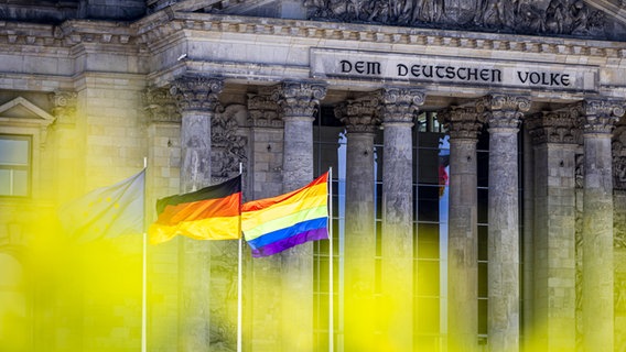 Die Europa-Fahne, die deutsche Flagge und eine Regenbogenflagge sind vor dem Reichstag in Berlin gehisst. © picture alliance/photothek Foto: Leon Kuegeler