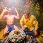 Flötzinger (Daniel Christensen) und Franz (Sebastian Bezzel) vor einem Feuer auf einem Steinhaufen. © Constantin Film 