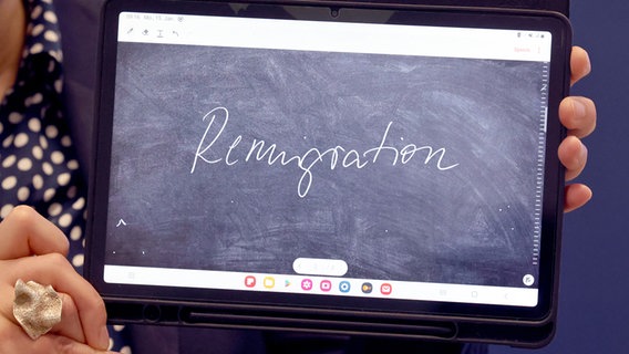 Hessen, Marburg: Der Begriff "Remigration" wird auf einem Tablet präsentiert. © dpa Foto: Nadine Weigel