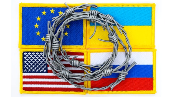 Fahnen von EU, Ukraine, Russland und den USA mit Stacheldraht © picture alliance | CHROMORANGE Foto: Christian Ohde