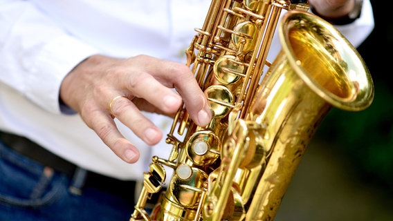 Ein Musiker spielt auf einem Saxophon. © picture alliance Foto: Hauke-Christian Dittrich