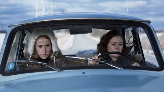 Szenenbild aus dem Film "Schlamassel": Zwei Frauen sitzen, durch die Frontscheibe betrachtet, nebeneinander in einem Auto. © JORONI Film, CZAR Film 