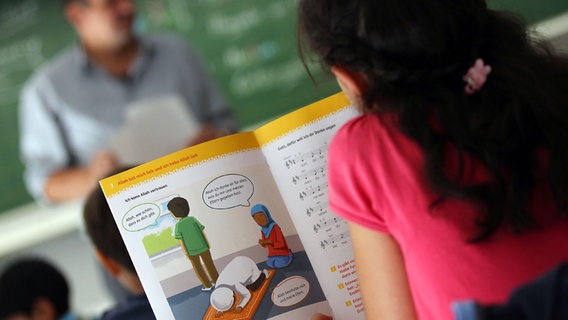 Ein Mädchen liest in einem Schulbuch. © picture alliance / dpa 