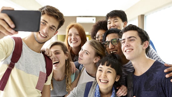 Eine Gruppe junger Menschen posiert für ein Selfie © picture alliance 