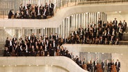 Das NDR Elbphilharmonie Orchester posiert mit Instrumenten auf den Rängen vor der Orgel im Großen Saal der Hamburger Elbphilharmonie. © NDR/Michael Zapf Foto: Michael Zapf