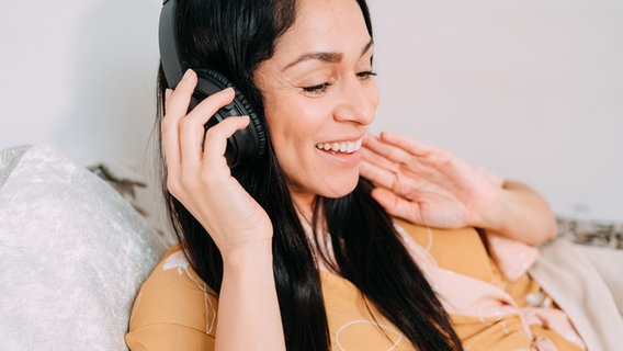 Frau hört freudig Musik über Kopfhörer © Photocase Foto: Addictive Stock