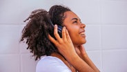 Frau hört über Kopfhörer Musik © Photocase Foto: Addictive Stock