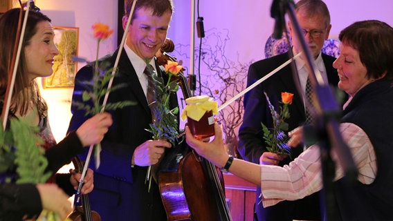 Die Musiker eines Streichquartetts werden nach ihrem Konzert mit Blumen beschenkt. © ndr.de 