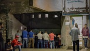 Zu sehen ist der Eingang der Hamburger Al-Nour Moschee. Der Gebetsraum in einer ehemaligen Tiefgarage ist so voll, dass die Männer bis auf die Einfahrtsrampe hinaus stehen. © Özgür Uludağ Foto: Özgür Uludağ