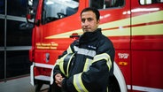 Mohammad Ibrahimi steht vor einem Feuerwehrauto der Freiwilligen Feuerwehr in Achim. © Julius Matuschik Foto: Julius Matuschik