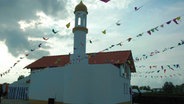 Eine Aussenansicht der mit Girlanden geschmückten Bait-ul-Karim-Moschee in Stade. © Ahmadiyya Muslim Jamaat Deutschland KdöR 