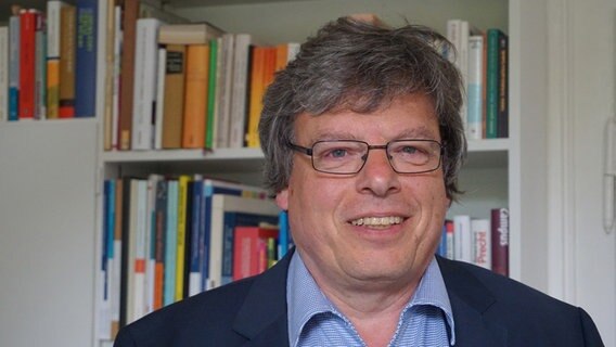 Nahaufnahme von Hans-Peter Daub, vom Theologischen Vorstand der Dachstiftung Diakonie, vor einem Bücherregal. © keine rechtlichen Beschränkungen 