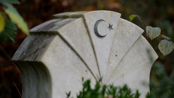 Ein muslimischer Grabstein mit einem Sichelmond und einem Stern, daneben eine Efeuranke © picture alliance / Frank May Foto: Frank May
