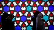 Women pray in front of a colorful window in a mosque.  © photo alliance / photo library Photo: Thomas Trutschel
