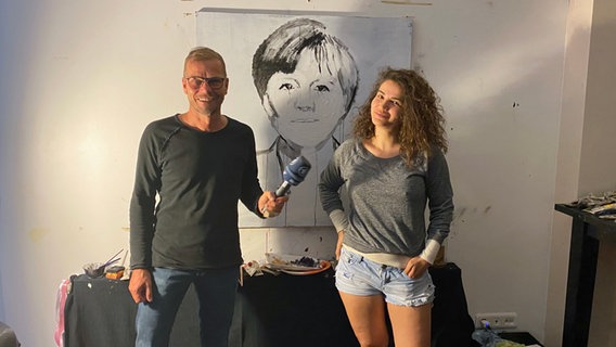 Die Istanbuler Künstlerin Özgecan Uluer und Christian Buttkereit, ARD-Korrespondent in Istanbul, vor Uluers Angela-Merkel-Porträt. Die Istanbuler Künstlerin Özgecan Uluer und Christian Buttkereit, ARD-Korrespondent in Istanbul, vor Uluers Angela-Merkel-Porträt. © ARD Foto: Imran Mirza