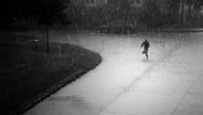 Eine Person rennt bei strömendem Regen. © photocase Foto: tobeys
