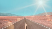Ein Highway in der Wüste im kalifornischen Death Valley läuft auf den Horizont zu. © photocase / Martina Birnbaum Foto: Martina Birnbaum
