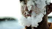 Das Gesicht eines jungen Mannes ist durch den Rauch seiner E-Zigarette verhüllt. © photocase | Jared Thompson Creative Foto: Jared Thompson Creative