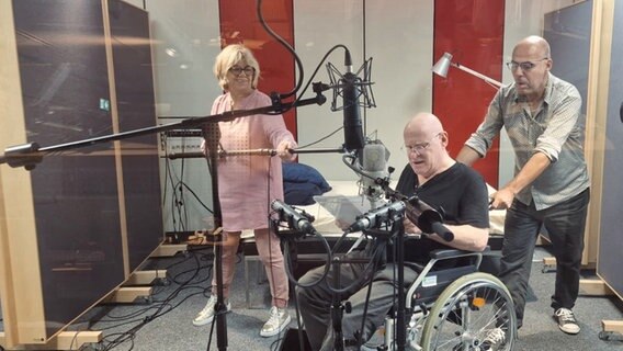 Drei Personen nehmen im Tonstudio eine Szene mit Rollstuhl auf. © NDR / Julia Werth Foto: Julia Werth