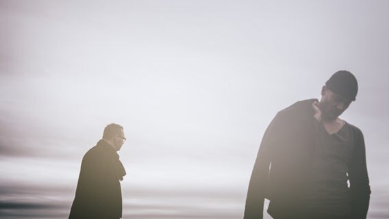 Zwei Männer stehen mit Abstand von einander und schauen in unterschiedliche Richtungen. © photocase / busdriverjens Foto: busdriverjens