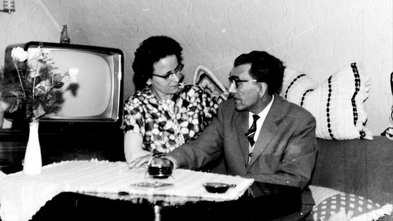 Schwarz-weiß Foto: Eine Frau und ein Mann unterhalten sich in einem Wohnzimmer, ca. 1960er Jahre. © photocase | Sebastianus Foto: Sebastianus