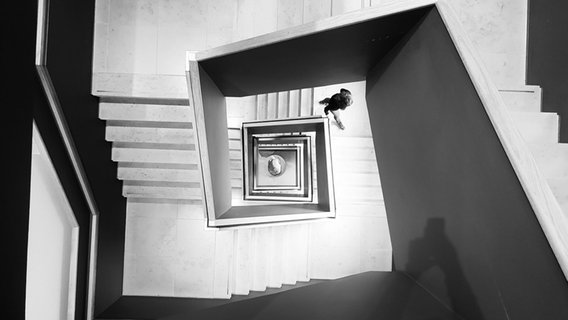 Ein Blick in ein Treppenhaus, in dem eine Person aufsteigt. © photocase / MPower. Foto: MPower.