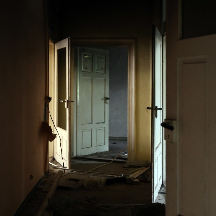 Ein dunkler Gang mit mehreren offenen Türen. © photocase | time. Foto: time.