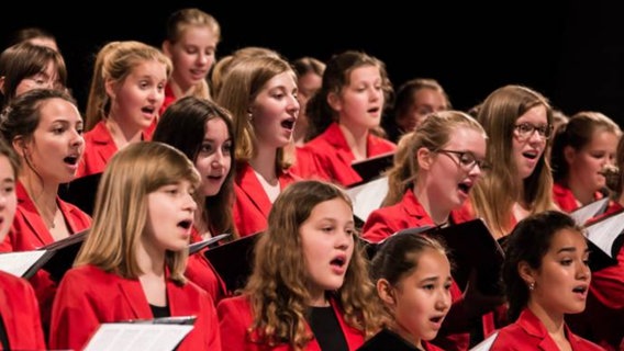 Mitglieder des Mädchenchors Hannover in roten Blazern während eines Auftritts 2017. © Anke Schroefel Foto: Anke Schroefel