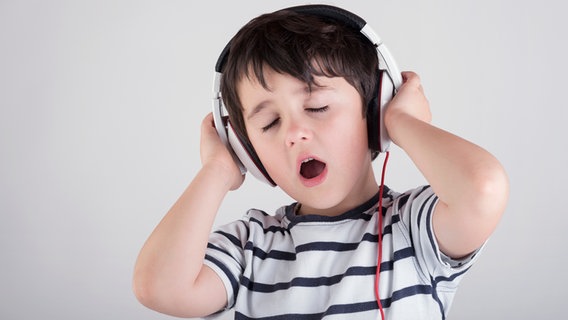 Junge hört über Kopfhörer Musik und singt. © photocase.de Foto: estherm