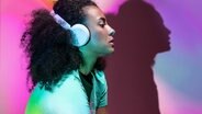 Nachdenkliche Frau hört Musik in Neonfarben © photocase.de Foto: Addictive Stock