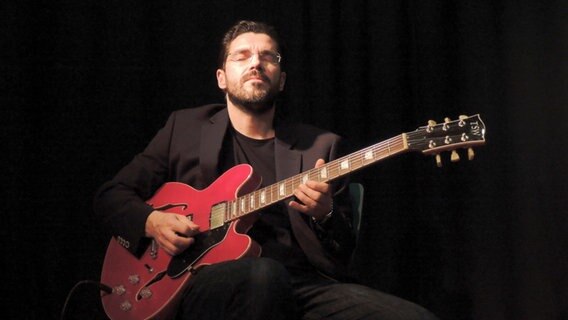 Joscho Stephan spielt bei einem Konzert mit geschlossenen Augen Gitarre. © picture alliance / Sven Thielmann Foto: Sven Thielmann