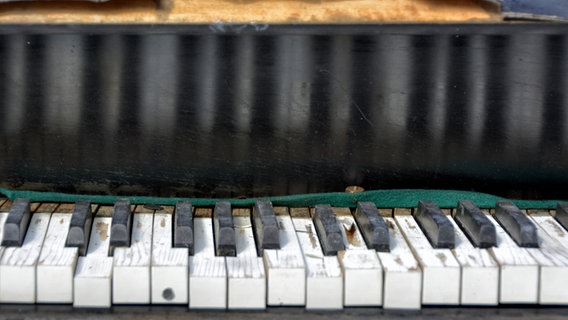 Die beschädigte Tastatur eines alten Klaviers © picture alliance / Zoonar 