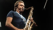 Der Saxofonist Stan Getz spielt vor einem Mikrofon ein Tenorsaxofon. © picture alliance / kpa 